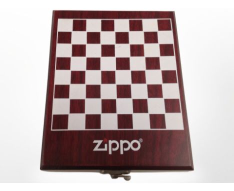 A Zippo miniature chess set in fitted box containing a further Zippo lighter, hip flask, Swiss Army-style knife, and funnel.