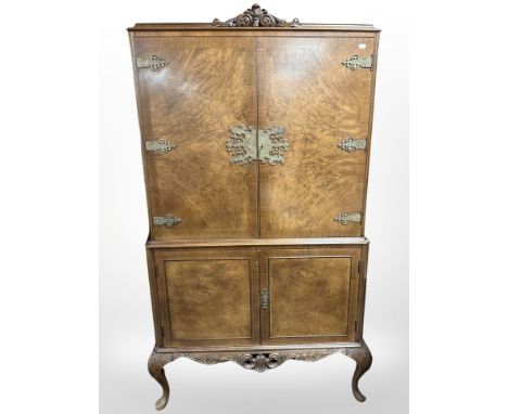 A 20th-century burr walnut brass-mounted drinks cabinet on cabriole legs, 93cm wide x 44cm deep x 158cm high.