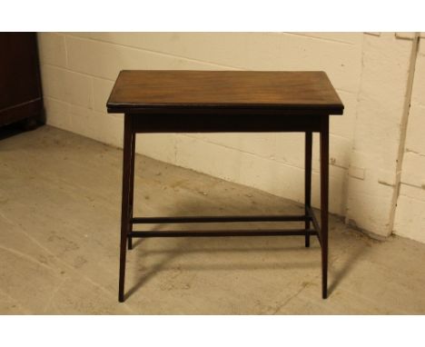 An Edwardian mahogany fold over card table cross banded in satinwood and supported on square tapering legs united by a double