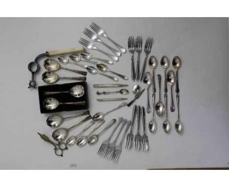A collection of silver plated flatware to include teaspoons, dessert forks, wick scissors, and an ivorine handled bone clamp 