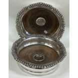 An oversized pair of Victorian silver wine coasters.