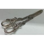 A pair of silver grape scissors embossed with foxes and foliage.