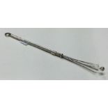 A silver collapsible swizzle stick.