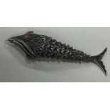 An Antique silver articulated model of a fish with filigree decoration.