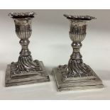 A pair of Victorian silver candlesticks on square bases.