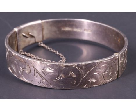 An engraved silver bangle, having an offset catch, Birmingham, 1972, 35.46 g, 12 mm wide, 54 x 56 mm internally 