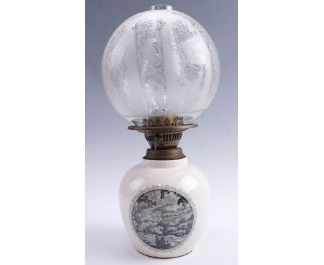 A transfer printed porcelain oil lamp having an etched glass globe, 40 cm