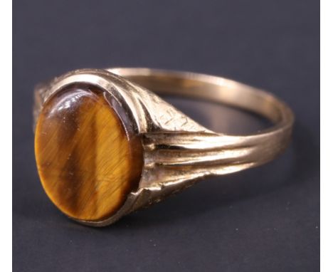 A 1970s tiger's eye signet ring, having a 9.5 x 8 mm vacant matrix set in a bark textured semi-bezel between fluted shoulders