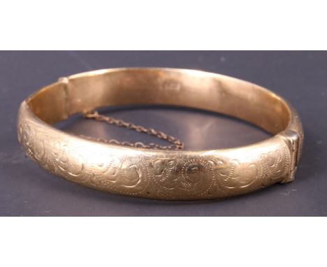 A 1960s 9 ct gold bangle, decorated with engraved scrolls, wax filled, Birmingham, 1966, 15.26 g, 52 x 58 mm internally, 10.5