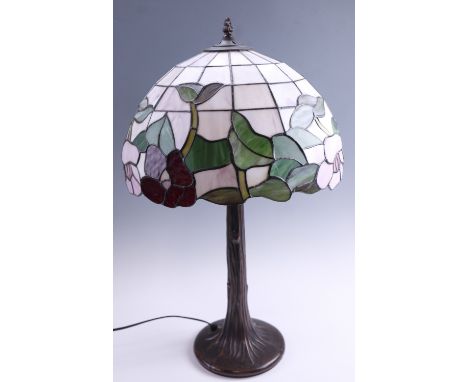 A late 20th Century Tiffany style table lamp, having a leaded glass shade on a patinated naturalistic base, 66 cm high overal