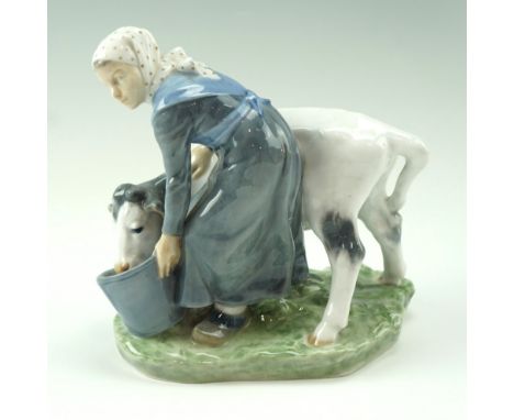 An early 20th Century Royal Copenhagen figurine of a milk maid weaning a calf, incised signature to the base, model number '7