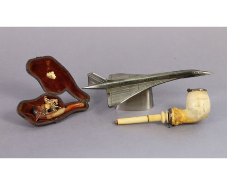 A cast-iron novelty “Concorde” desk lighter, 8½” long; together with two Meerschaum pipes, one cased.