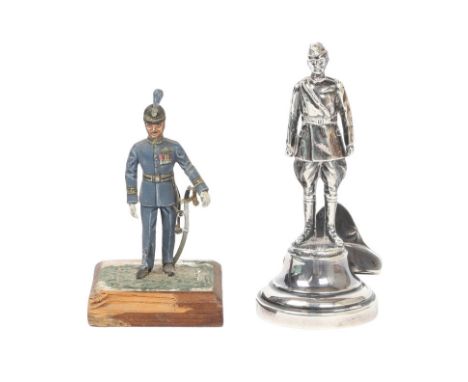 SILVER FIGURE IN THE FORM OF AN RFC OFFICER AND A PAINTED FIGURINE (2). A silver menu/place stand in the form of a Royal Flyi