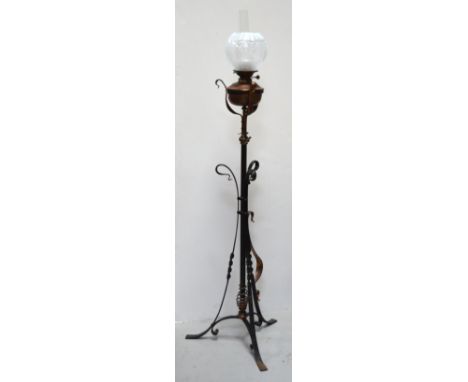A freestanding cast iron standard lamp with glass chimney and shade, height 161cm.