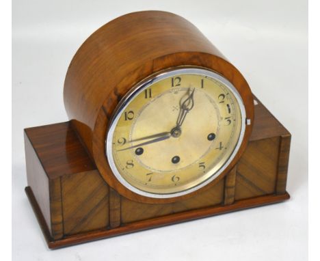 An early walnut cased mantel clock in the Art Deco style, the silvered dial set with Arabic numerals, height 22cm.