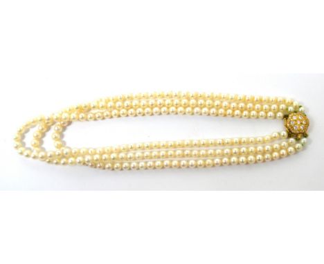 A triple strand cultured pearl necklace terminating in an 18ct and diamond clasp, presented in Boodle and Dunthorne box.