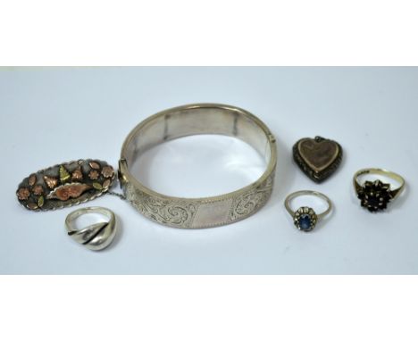 A hallmarked silver bangle, three silver rings, a silver locket and a Victorian hallmarked silver and gold mounted brooch (6)