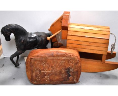 A wooden rocking elephant, a smaller leather covered standing model of a horse and a Middle Eastern stuffed pouffe (3).