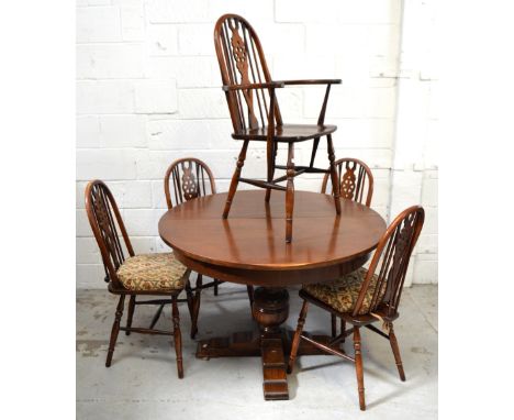 A circular oak dining table raised on central bulbous support and outstretched quadripartite support, width when extended app