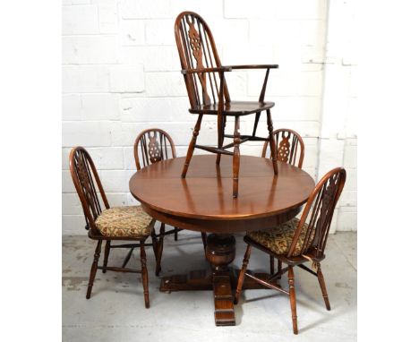 A circular oak dining table raised on central bulbous support and outstretched quadripartite support, width when extended app