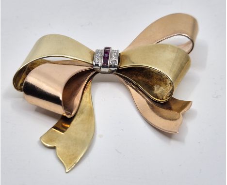 A bi-colour 14ct. gold, diamond and ruby bow brooch, the centre channel set four square cut rubies and pave set four eight-cu