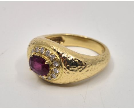 An 18ct. gold, diamond and synthetic ruby ring,&nbsp;four claw set mixed oval cut synthetic ruby to raised centre bordered by