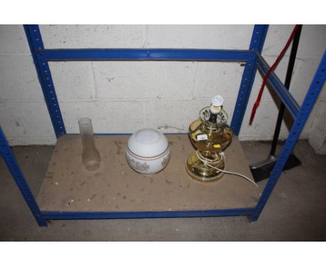 A brass oil lamp converted to electricity with shade and chimney