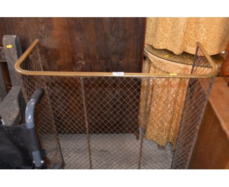 A brass and wirework fireguard 