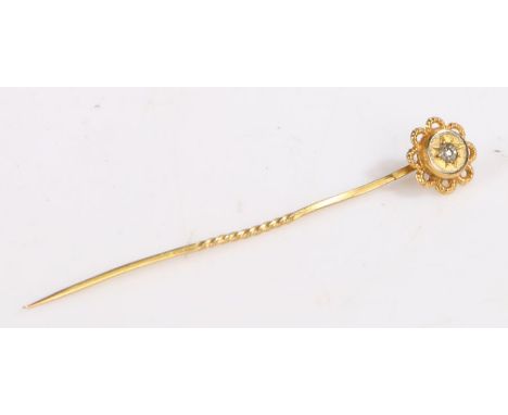 A 9ct yellow gold stick pin, the floral head set with one round cut diamond.Approx. diamond carat weight. 0.03ct. Colour: J-K