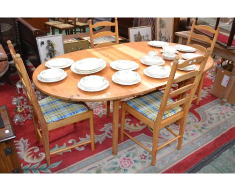 An Ercol pine extending dining table and four pine ladderback chairs