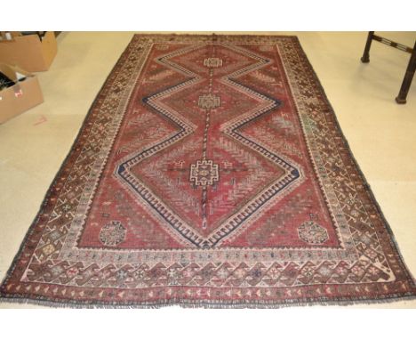 A shiraz carpet, woven in shades of burgendy and deep blue, 2.95m x 1.62m