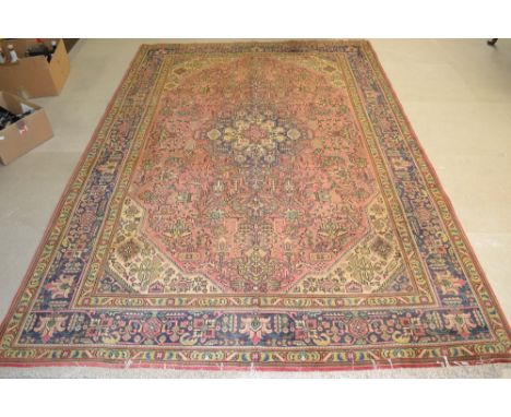 A Tabriz carpet, woven in shades of red and blue on a cream ground, 2.9 meters x 1.95 meters