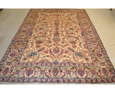 A Tabriz carpet, woven in shades of red, blue and gold, 2.76m x 1.76m