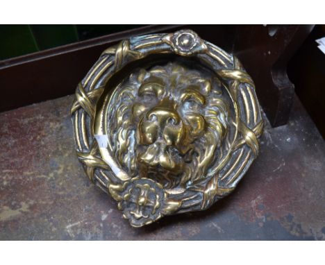 A large brass lion mask door knocker