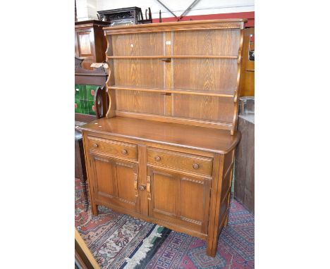 An Ercol dresser, shaped back, two short drawers over two panel door cupboard