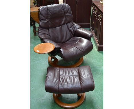 A Stressless reclining and swivel armchair with matching pouffe