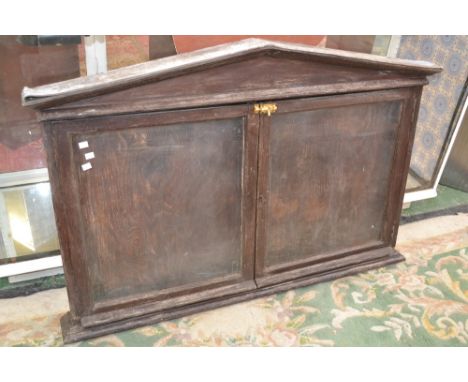 An early 20th century oak village/church notice board, glass doors to front, architectural pediment