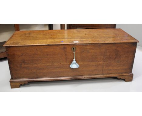 18th Century oak trunk, the hinged cover enclosing a void interior with candle box above plank sides and bracket feet, 108cm 