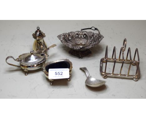 Silver trinket dish, silver toast rack, caddy spoon, three piece condiment set etc. 