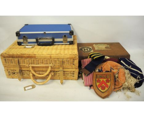 Vintage leather case bearing various shipping labels and containing a quantity of school caps, together with a picnic hamper 
