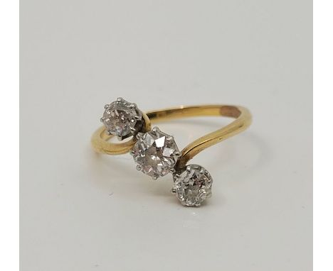 A precious yellow metal three stone diamond ring, set row of three graduated old-cut diamonds mounted at an angle to the band