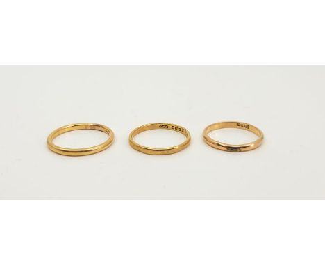 An Egyptian 18ct. gold band, stamped in Eastern Arabic numerals, size UK J 1/2+, together with two other 18ct. gold bands, si