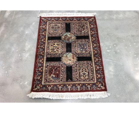 A SMALL PAK PERSIAN WOOL RUG (97 x 65cm)
Hand knotted wool, decorated with floral medallions, animal motifs and calligraphy
O