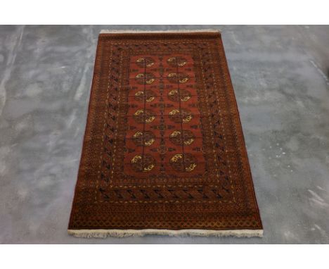 A PERSIAN KARAMAT WOOL RUG (192 x 109cm)
Hand knotted wool with a rust-red field featuring rows of repeating octagonal guls a