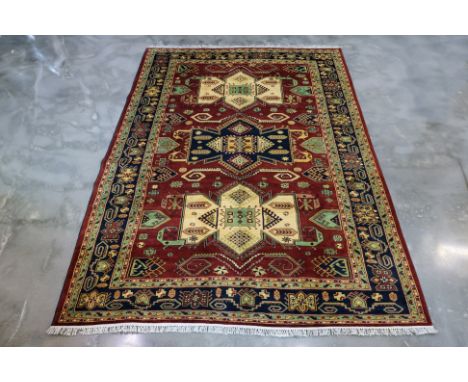 A TURKMEN WOOL CARPET (296 x 205cm)
Hand knotted wool pile featuring a burgundy field, medallions with hook motifs, framed by