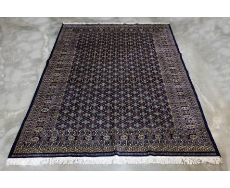 A KASHMIRI WOOL CARPET (307 x 250cm)
Hand knotted wool with a navy field, allover diamond lattice design, featuring intricate