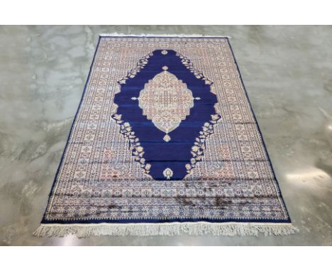 A KASHMIRI SILK AND WOOL CARPET (278 x 185cm)
Hand knotted wool with deep navy field featuring a central ivory medallion surr