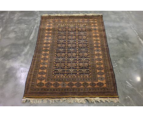AN ANTIQUE FILPA WOOL RUG (182 x 123cm)
Hand knotted wool with a brown and navy field featuring repeating geometric and triba