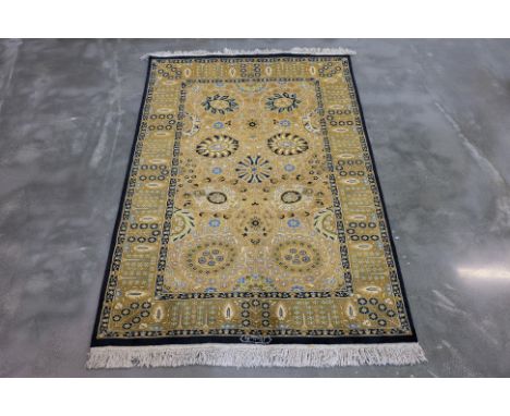 A PERSIAN WOOL RUG  (196 x 126cm)
Tightly hand knotted wool pile with floral medallions, symmetrical latticework and a navy b
