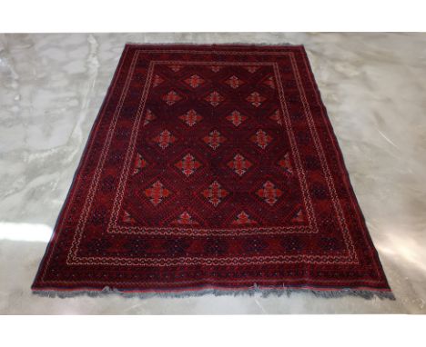 A TURKMAN TRIBAL WOOL CARPET (294 x 200cm)
Hand knotted wool pile with a deep red field, featuring a diamond lattice pattern 